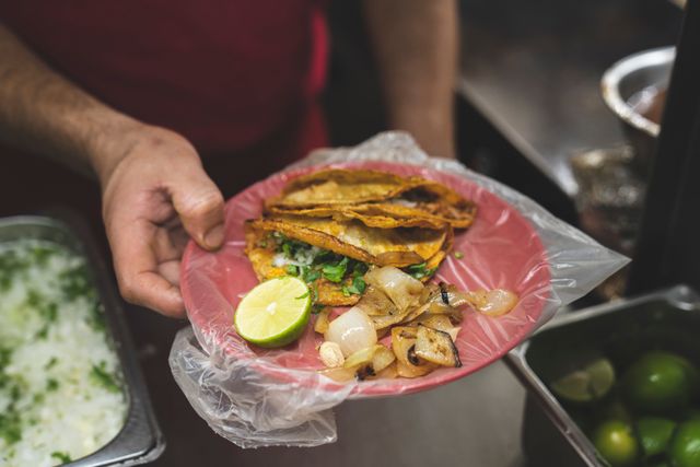 Fotografía ilustrativa de stock de tacos con cebolla y limón.